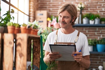 Sticker - Young blond man florist smiling confident reading document at flower shop