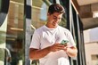 © Krakenimages.com - Young hispanic man smiling confident using smartphone at street