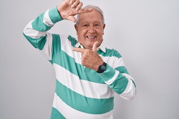 Sticker - Senior man with grey hair standing over white background smiling making frame with hands and fingers with happy face. creativity and photography concept.