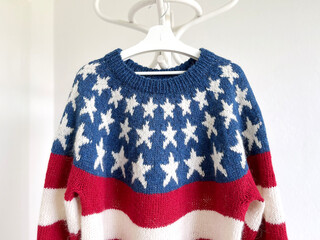 Wall Mural - USA Flag patriotic wool knitted lopapeysa sweater, red blue white pullover with stripes and stars in traditional Nordic pattern