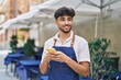 © Krakenimages.com - Young arab man waiter using smartphone working at restaurant