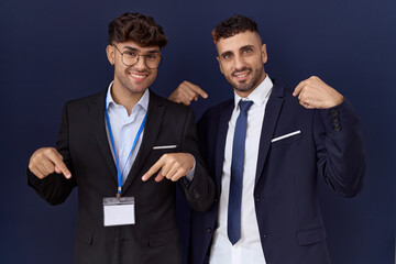 Canvas Print - Two hispanic business men wearing business clothes looking confident with smile on face, pointing oneself with fingers proud and happy.