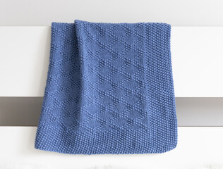 Wall Mural - Navy blue knitted blanket in brocade knitting pattern on a white background