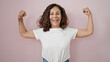 © Krakenimages.com - Middle age hispanic woman smiling confident doing strong gesture with arms over isolated pink background