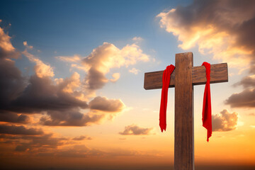 Wall Mural - Wooden cross with red cloth wrapped around on sunset sky background, crucifix and resurrection of Jesus
