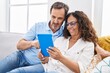 © Krakenimages.com - Man and woman couple using touchpad sitting on sofa at home
