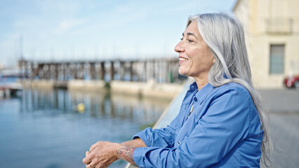 Middle age grey-haired woman smiling confident standing at seaside