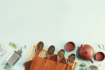 Beautiful set for traditional tea ceremony and tea collection in wooden spoons on light blue background