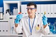 © Krakenimages.com - Young non binary man scientist holding urine test tubes at laboratory