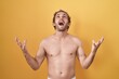 © Krakenimages.com - Caucasian man standing shirtless wearing sun screen crazy and mad shouting and yelling with aggressive expression and arms raised. frustration concept.