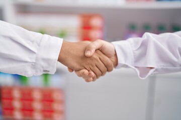 Poster - Two women pharmacist shake hands at pharmacy