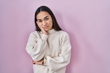 Wall Mural - Young south asian woman standing over pink background thinking looking tired and bored with depression problems with crossed arms.