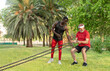 © ADDICTIVE STOCK - Strong man with trainer exercising with ropes in park