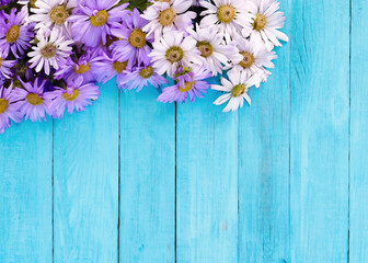 Wall Mural - Purple flower on blue wooden background from top view. Generative AI