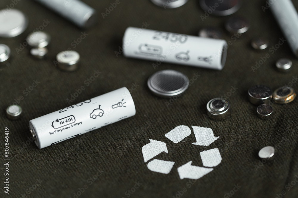 Flat lay with alkaline batteries on dark green background. Recycling chemical waste, environment and ecology saving concept. Hazardous E-Waste Recycling. Using rechargeable batteries