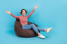 Full Length Photo Of Excited Funky Lady Wear Pink Shirt Sitting Bean Bag Empty Space Isolated Blue Color Background