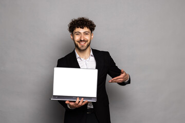 Wall Mural - Optimistic man pointing finger at laptop with blank display, showing empty screen, bragging with internet advertisement