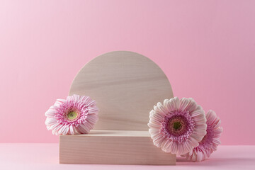 Wooden podium pedestal cosmetic beauty product presentation empty mockup on  pink background with gerbera flowers