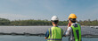 © NewSaetiew - Service engineer checking solar cell on the lake. Team electrical on site floating solar panels. Clean and Renewable energy concept.