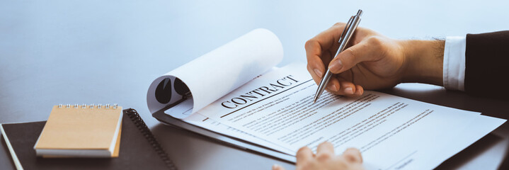 Wall Mural - Businessman signs contract agreement paper or business legal form with trust and professionalism. Closeup of hand holding pen in corporate meeting for official business deal. Equilibrium