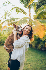 woman playing with her dog on the grass