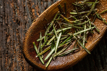 fresh organic freshly picked rosemary with dew or rain drops on top of rustic farmhouse wooden table, selective focus