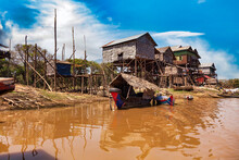 Kampong Phluk Floating Fishing Village, Boats And Houses On Stilts On Rural River In Drought Season. Tonle Sap Lake, Life And Work Cambodian People, Residents Poverty Country Cambodia. Copy Text Space