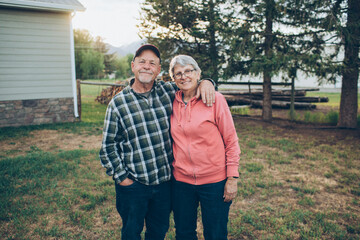 grandparents standing and hugging in the forest