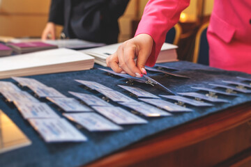 Process of checking in on a conference congress forum event, registration desk table, visitors and attendees receiving a name badge and entrance wristband bracelet and register electronic ticket