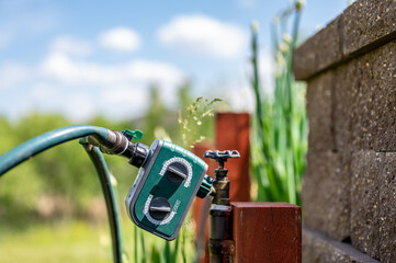 garden water timer on a spigot with a splitter and hoses.