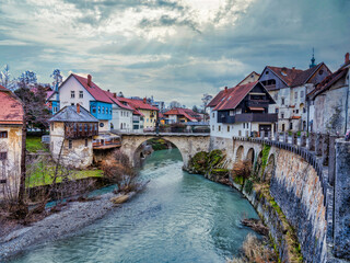 Wall Mural - Selca Sora river, riverside old houses and the Capuchin Bridge during a cloudy afternoon in Skofja Loka village, Slovenia