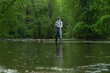 © vadimborkin - Fisherman catching brown trout on the fly standing in river.