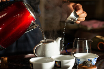 Wall Mural - pouring tea into a teacup	