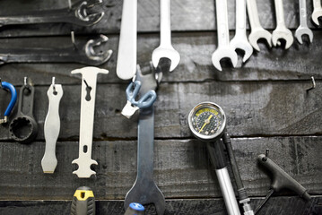 Wrenches and other hardware hanging on a tool board in a bicycle repair shop. Close up frontal view.