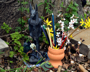 Wall Mural - Anubis Egypt god figurine with candles and flowers on ritual altar. Occult, esoteric and divination still life. Mystic outside background with vintage objects