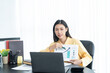 © ND STOCK - Young Asian business woman employee or executive manager using computer looking at laptop and talking leading hybrid conference remote video call virtual meeting or online training working in office.