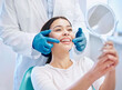 © Jade Maas/peopleimages.com - Dental consultation, mirror and woman with smile after teeth whitening, service or mouth care. Healthcare, dentistry and happy female patient with orthodontist for oral hygiene, wellness and cleaning