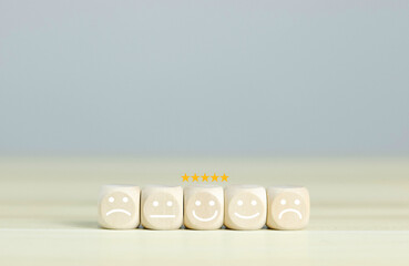 Emotional face symbols on wooden blocks Service ratings, ratings, customer reviews, satisfaction, evaluations, experience, and quality product marketing feedback.	
