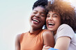 © Anela R/peopleimages.com - Couple of friends, black women and hug outdoor while laughing with freedom, happiness and lgbtq love. Face of happy, lesbian and african people together for space in sky or funny adventure in London