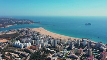 Wall Mural - Tourist Portuguese city of Portimao aerial view on a sunny day. South Portugal Algarve. bay in the background and liner