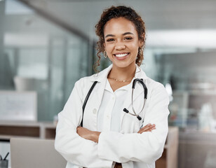 Healthcare, portrait of woman doctor with arms crossed and with stethoscope in a hospital building happy with a lens flare. Medical, wellness and female surgeon or nurse smile excited in a clinic