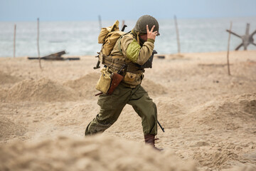 Historical reconstruction. An American infantry soldier from the World War II  fighting on the beach. Hel, Poland