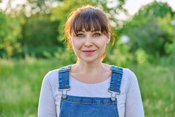 Wall Mural - Outdoor headshot portrait of mature smiling woman in countryside