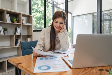 asian businesswoman sit at their desks and calculate financial graphs showing results about their in