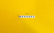 © photoopus - Measure Word and Concept Image. Letter Tiles on Yellow Background. Minimal Aesthetics.