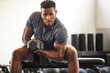 © Nkalipho M/peopleimages.com - Black man, bodybuilder and dumbbell in gym portrait for fitness, focus or training for growth, goal or competition. African guy, weightlifting and strong arms for training, wellness and muscle health