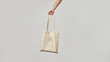 Cloth bag in hand on light background. Bag shoper in the hand