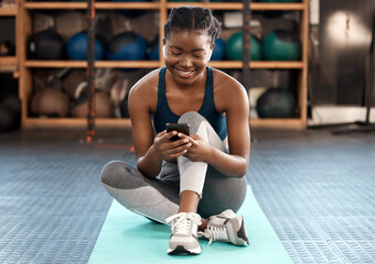 happy black woman, fitness and phone for social media, communication or networking at the gym. afric