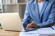 © ArLawKa - hand of business woman hold smartphone use analyzing and calculating the annual income and expenses, a financial chart and financial report, technology and bussiness concept.