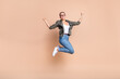 Full length photo of excited lucky lady dressed khaki shirt jumping high rising fists isolated beige color background